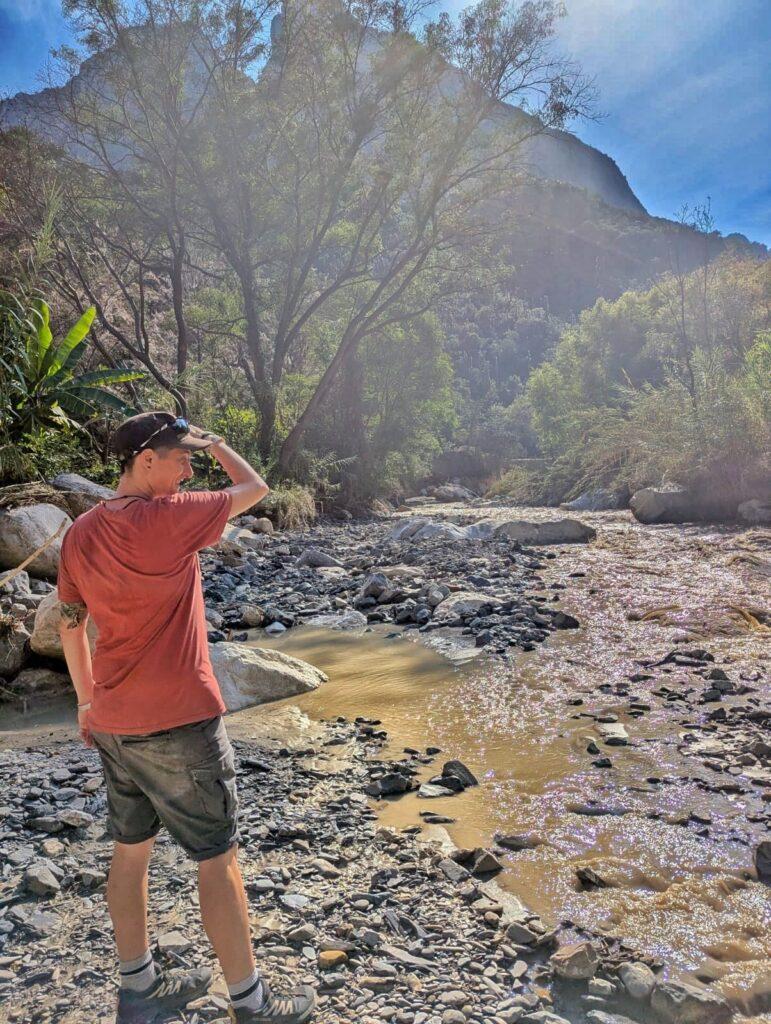 Cass standing by a brown, shallow river