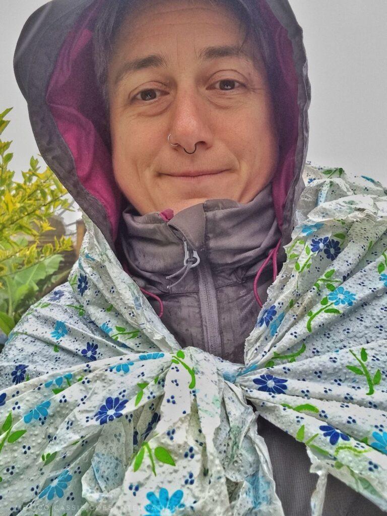 Cass in the rain - grey raincoat and a plastic table cloth tied over it