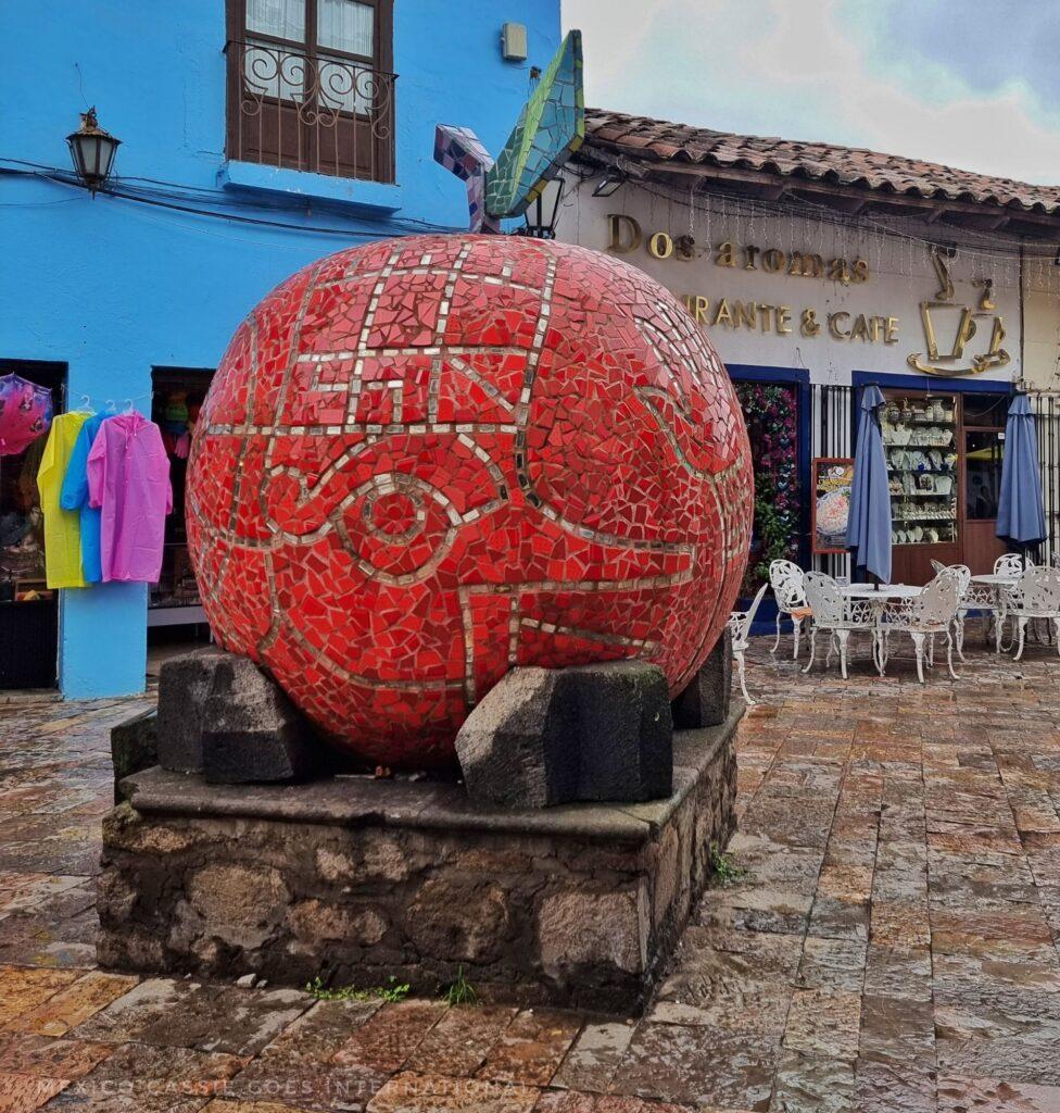 large mosaic sculpture of an apple on a plinth