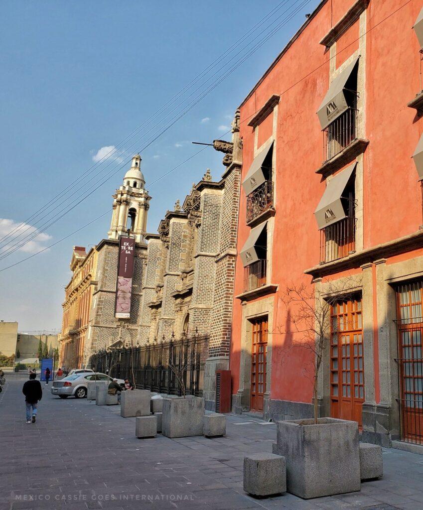 view of the sinking art gallery from outside next to a red 3 storey building