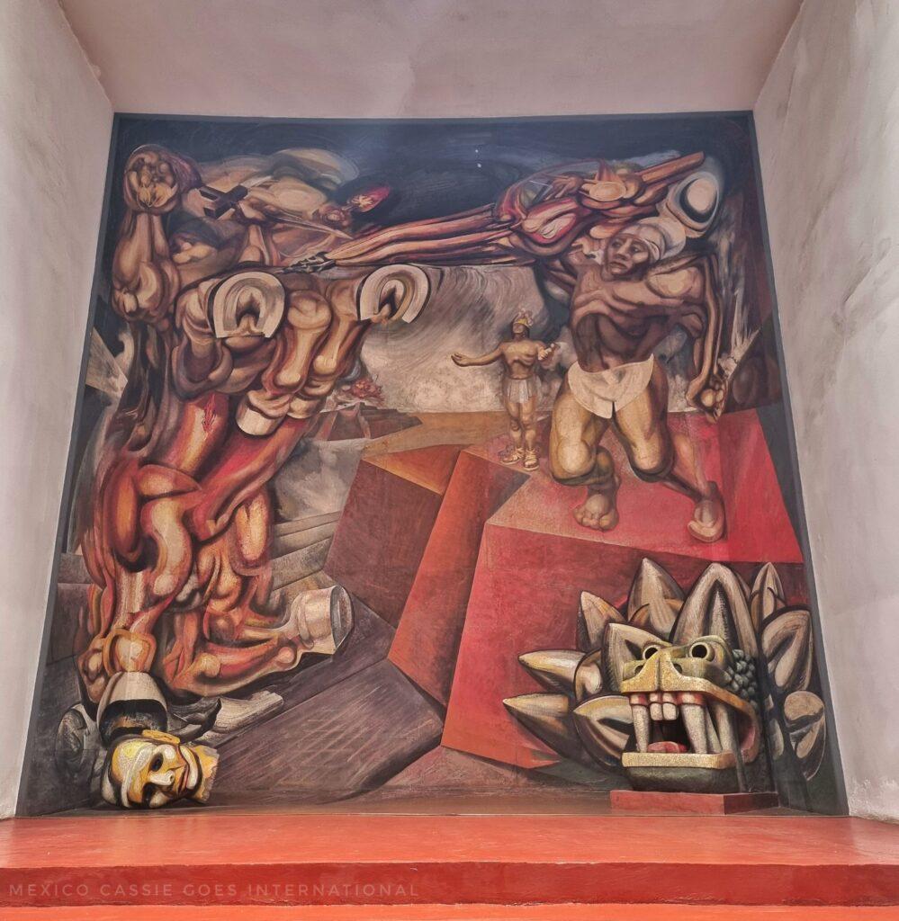 full mural with a dragon head in bottom right corner, man in loin cloth above