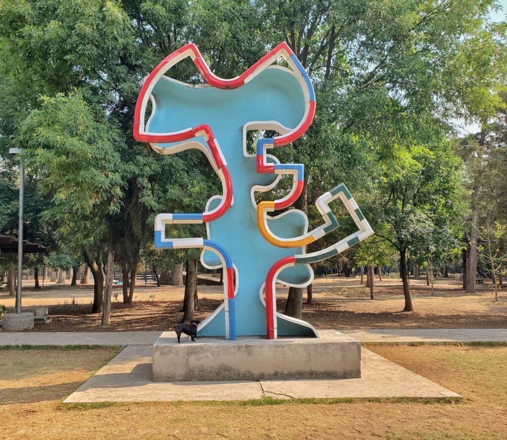 blue and red sculpture in a park