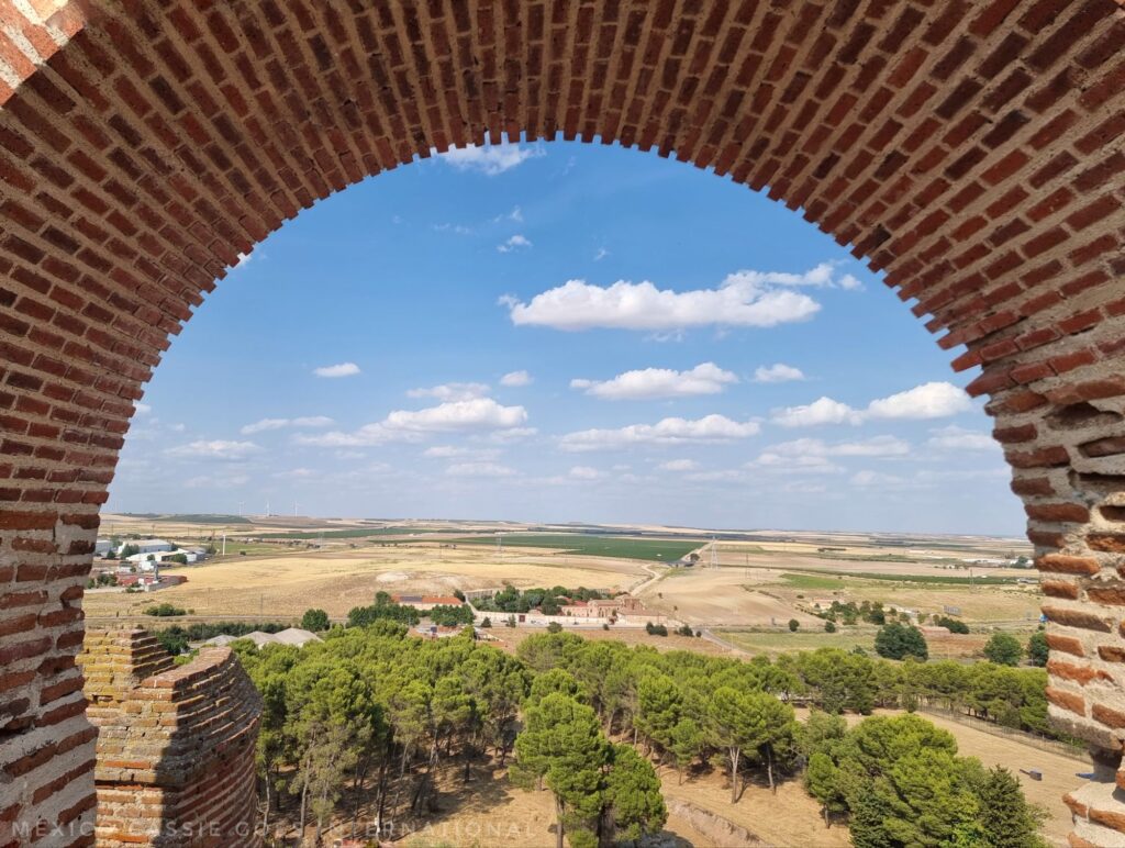 view through a brick arch of flat countryside