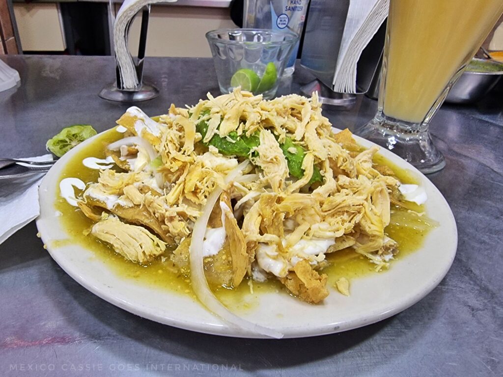 plate of chilaquiles bathed in green salsa
