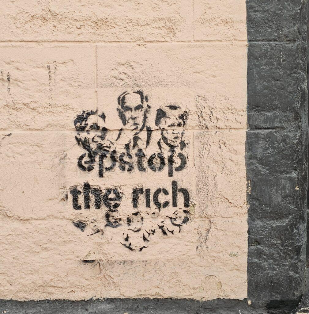 stencil on the wall - says estop the rich and has Netanyahu, Esptein and Trump there