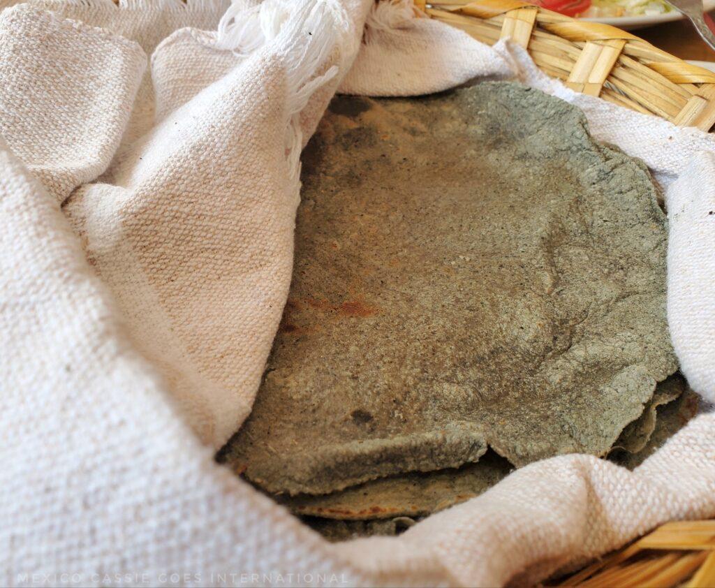 hand made blue corn tortillas in a white cloth