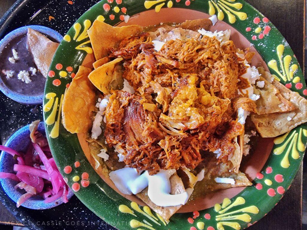 bowl of cochinita pibil (green bowl) with totopos