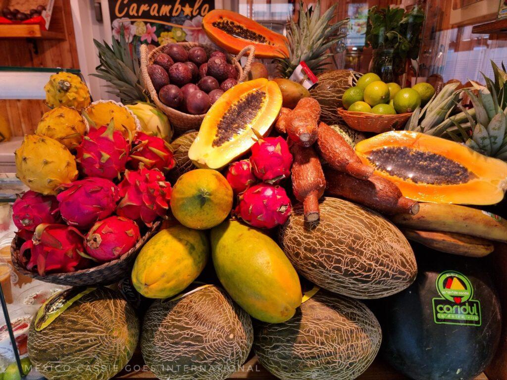 selection of fruits on a market stand - papaya, dragon fruit, passion fruit