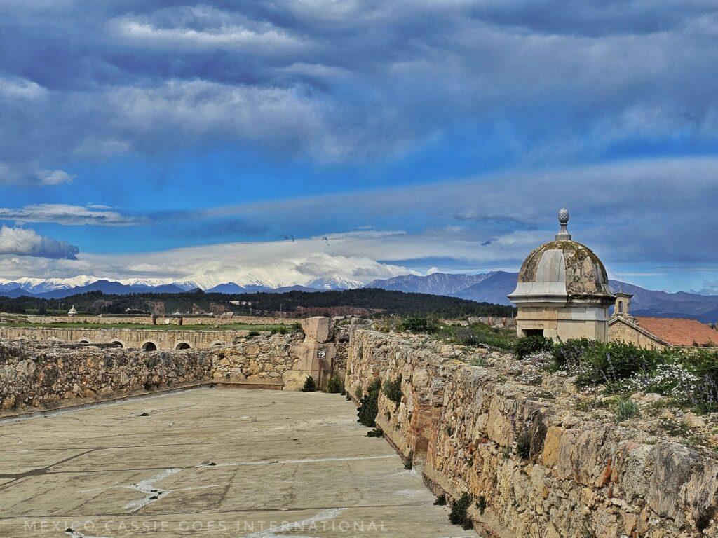 view of castle walls with snowy mountains in background