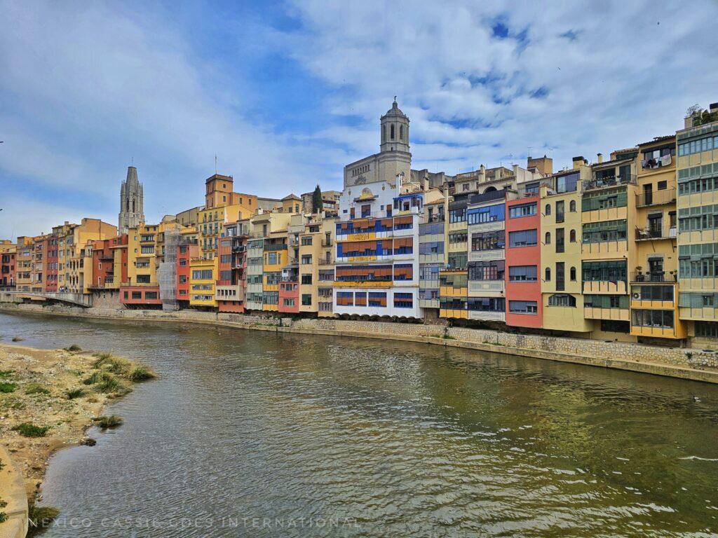 view along the river in girona with colourful buildings on bank