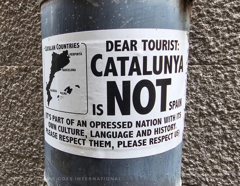 white sticker on drain pipe explaining that tourists need to know that Catalunya is not Spain