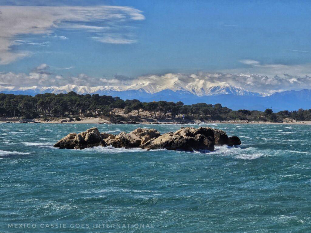 wild blue ocean, rocks, mountains in distance