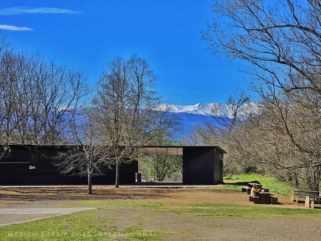 forest entrance in Girona - 1 storey building, trees, mountains in the background