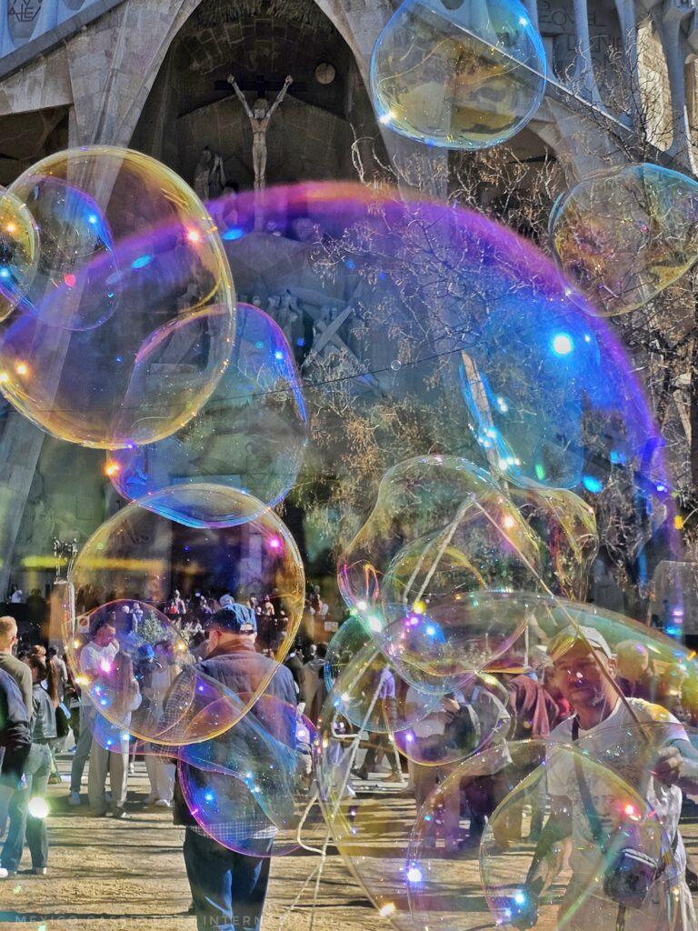 Sagrada Familia through bubbles, lots of people milling around