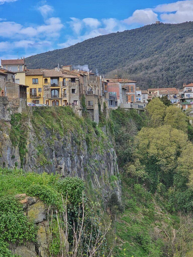 houses perched on cliff side, trees below