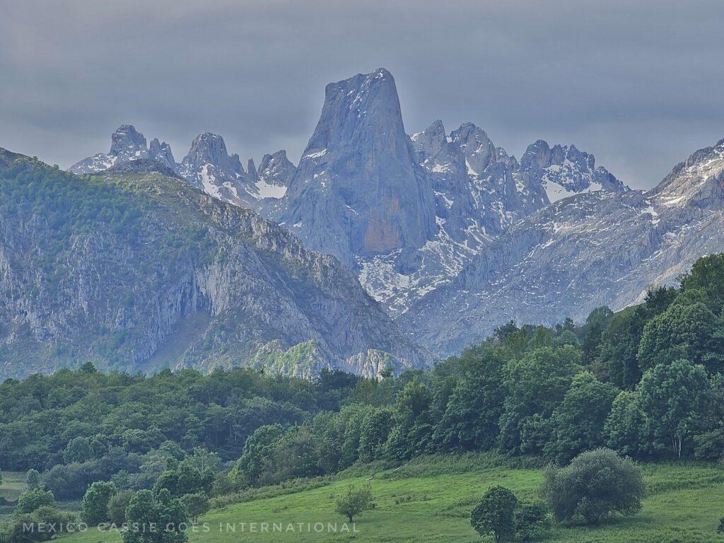 view of the naranjo de bulnes - an impressive monolith sticking up from the snow capped mountains