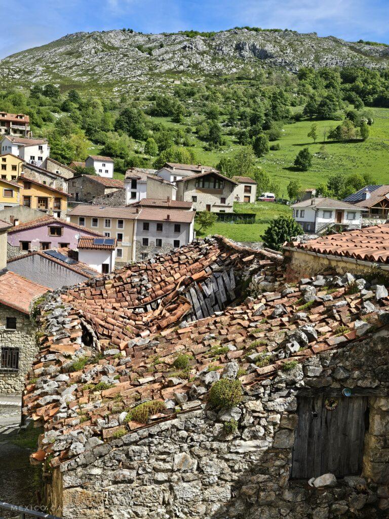 looking over mountain village, roof in foreground is pretty much caved in