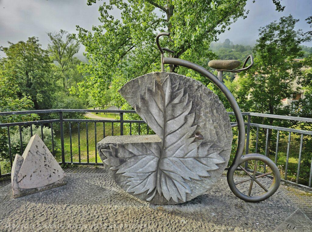 penny farthing style bike (sculpture) where the wheel is a cabrales cheese made of concrete