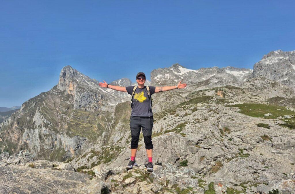 Cass, arms out in front of mountain range