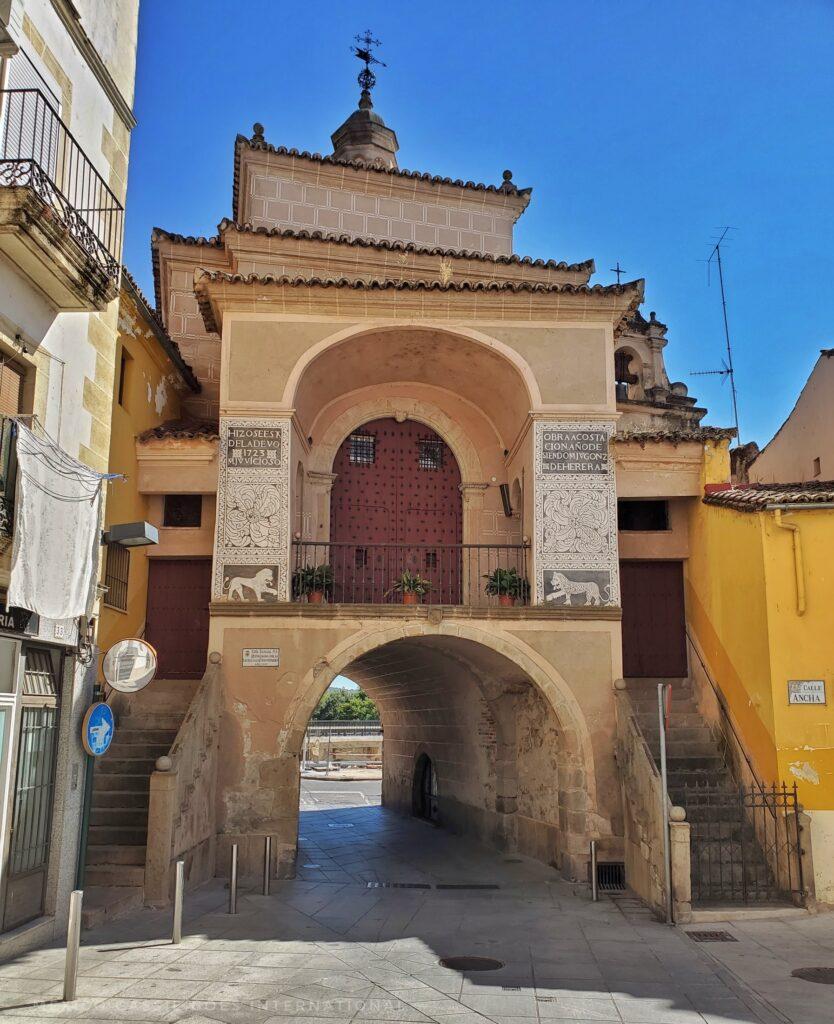 arched small tunnel gate with square building with another arch on top