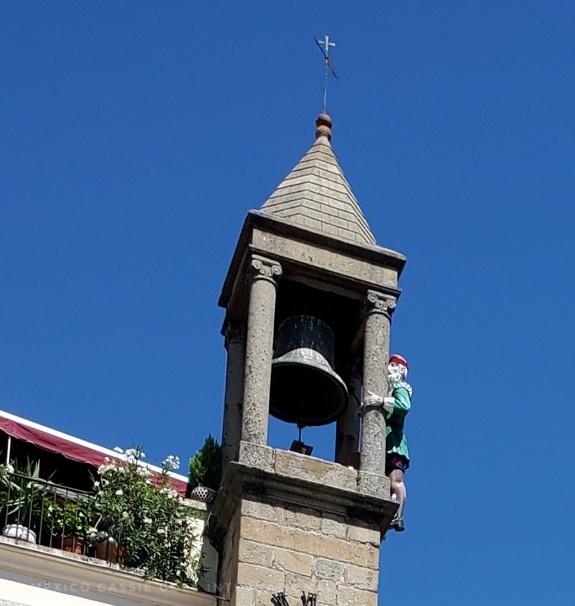 close up of the abuelo mayorga (statue hanging onto a bell tower)