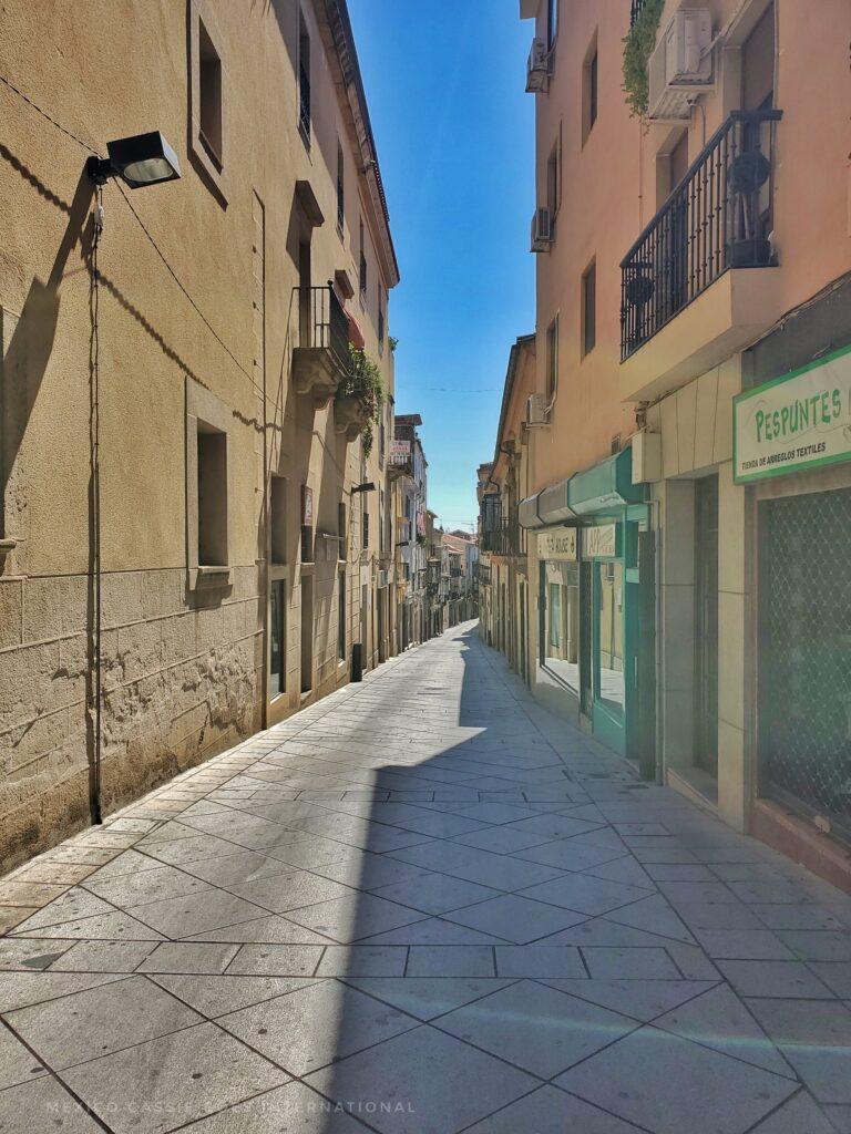 narrow, pedestrianised street between buildings, blue sky