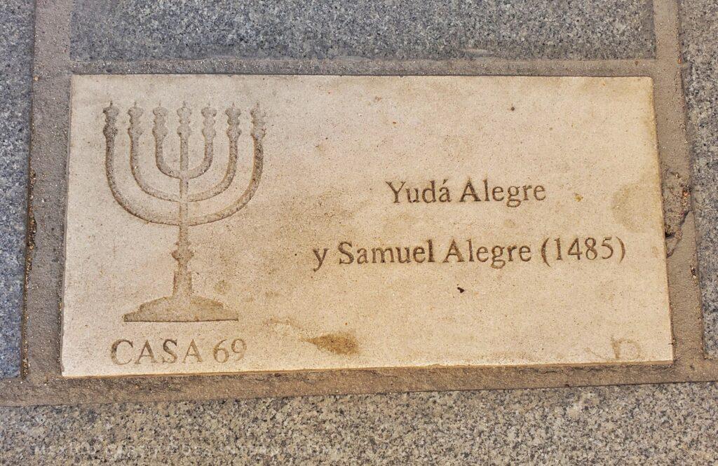 plaque on the floor, on left a menorah, on right the names Yudá Alegre y Samuel Alegre (1485)