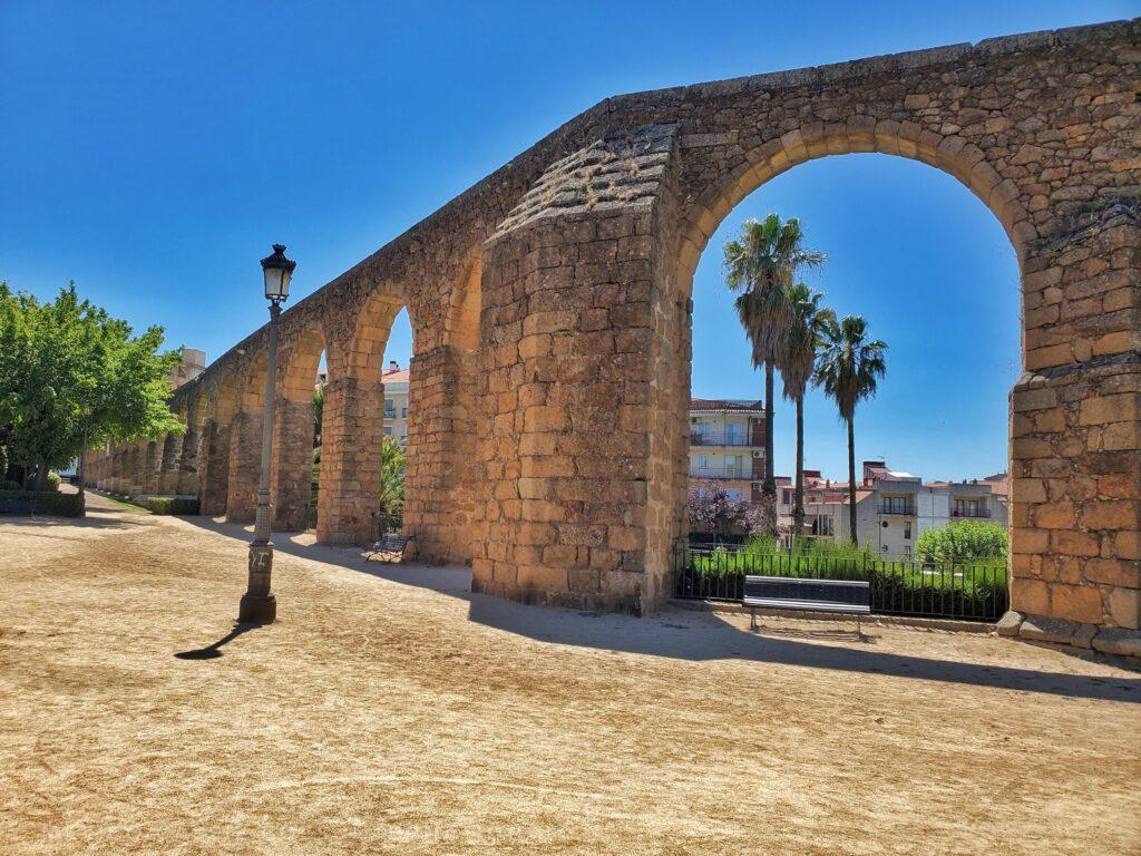 acueduct with palm trees visible through first arch