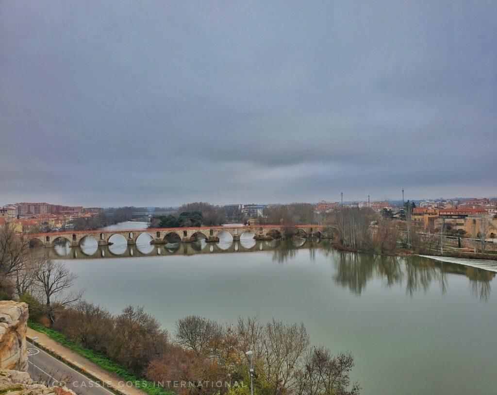 12th century arched bridge over the river, grey sky, winter's day