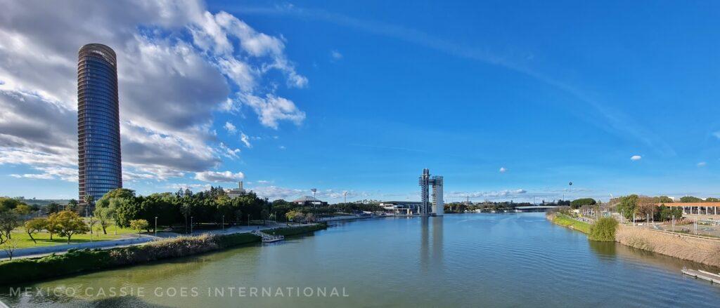 panoramic view over the river in sevilla, torre de sevilla on left, torre schindelar in middle of photo, river and blue sky