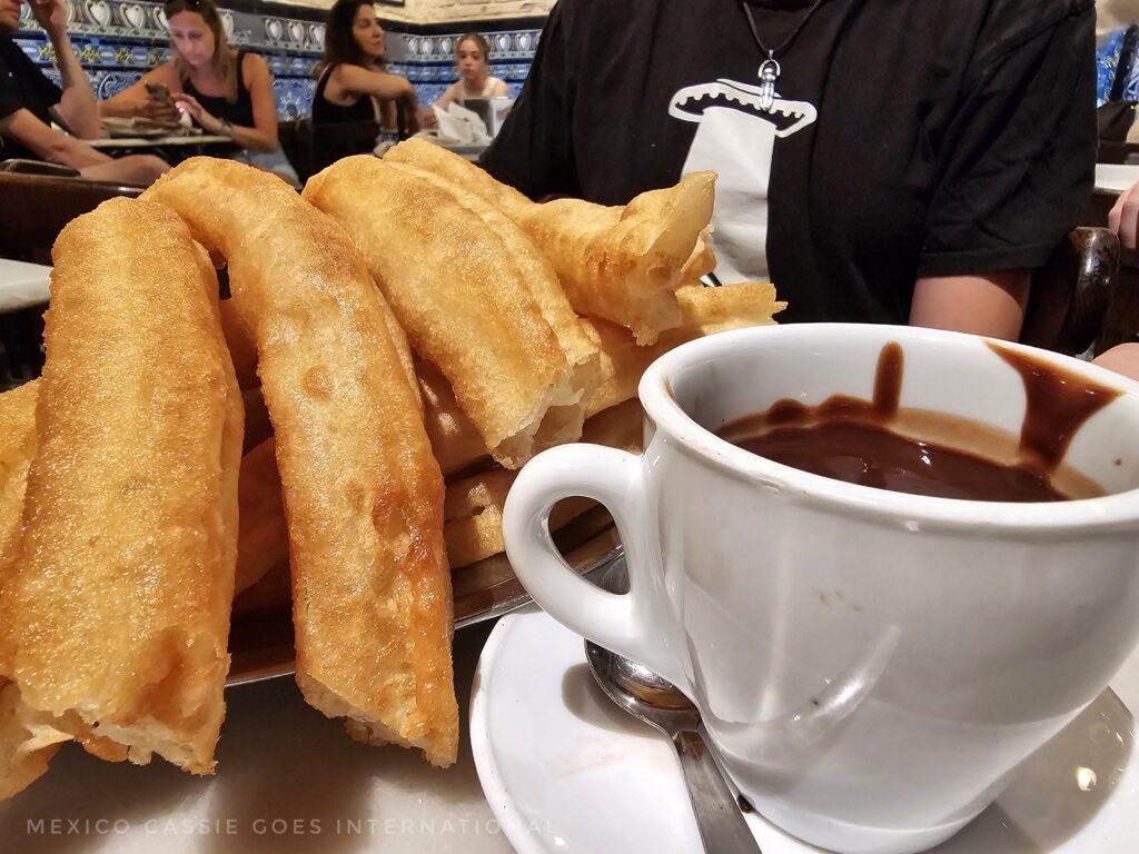 close up of cup of chocolate and churros