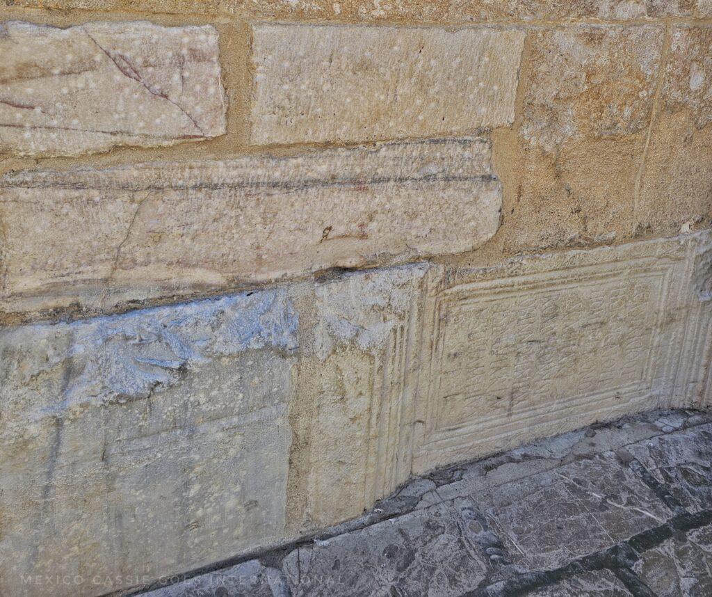 boring photo of stones in a wall but the bottom layer is actually Roman grave stones