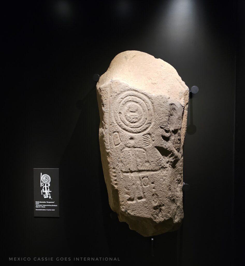 stone with ancient carvings on it and small (unreadable description)