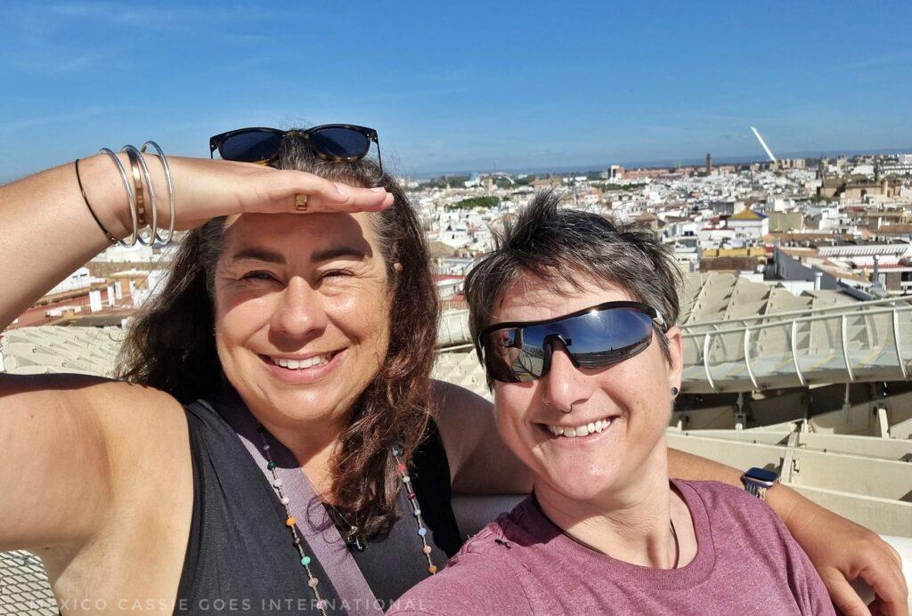 Cass and happy female client (shading eyes against sun) on las setas in sevilla. blue sky