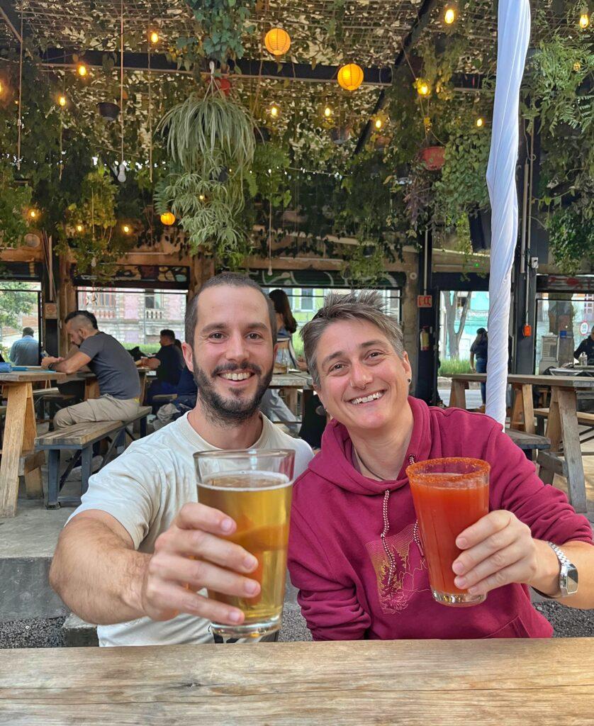Jaime and Cass drinking beers together in a bar