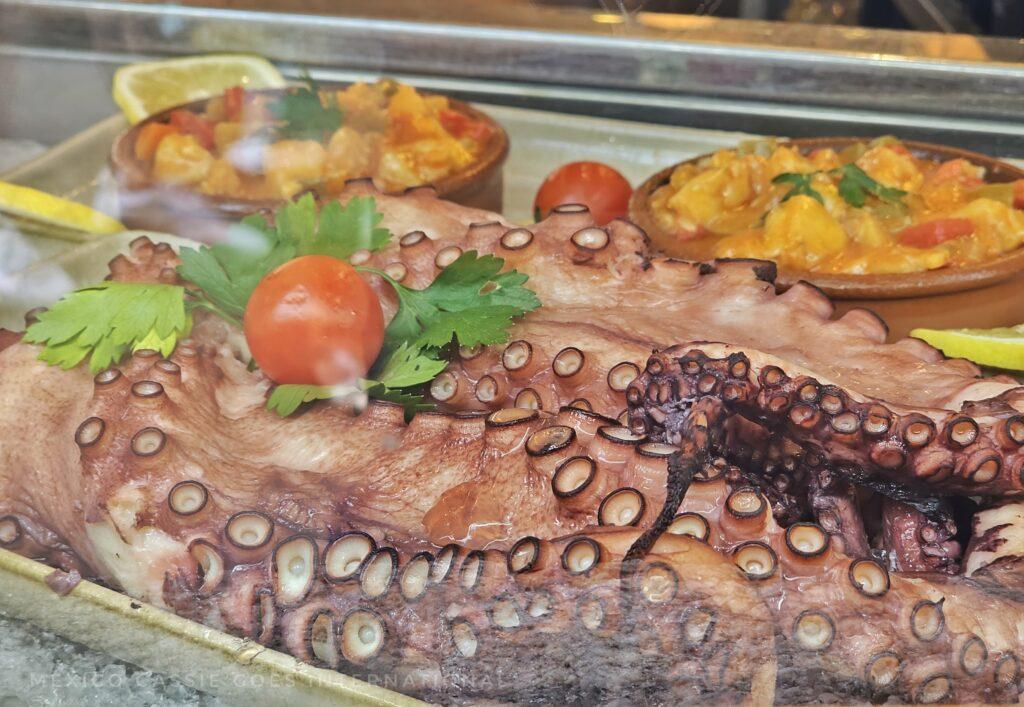 prepared octopus on a plate with salad