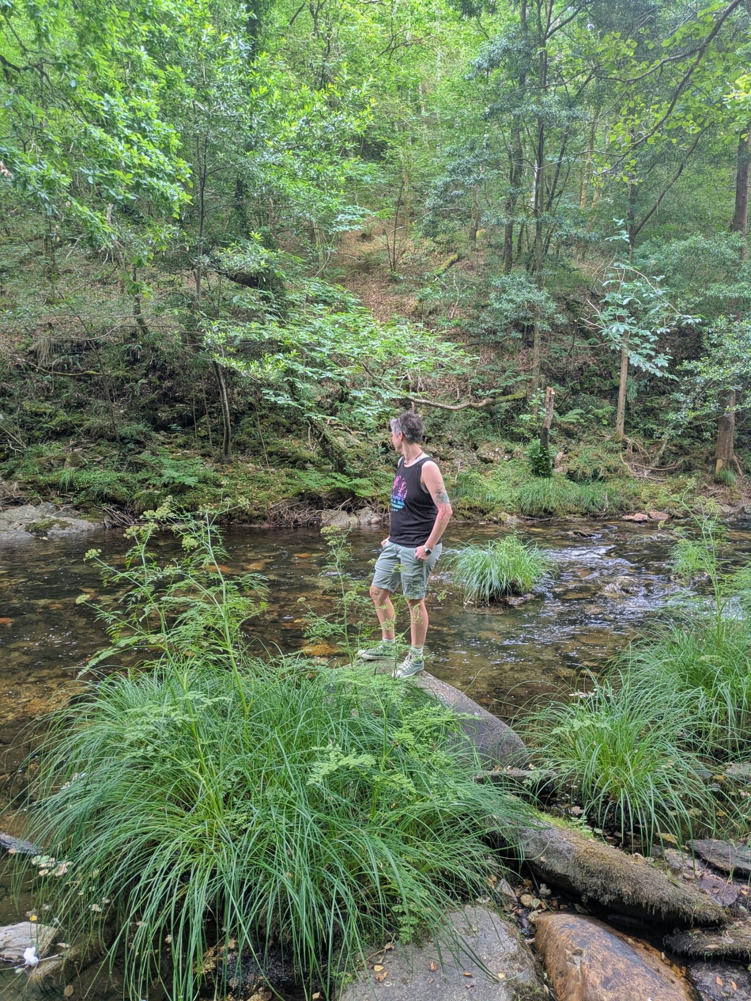 Cass standing on rock surrounded by green nature
