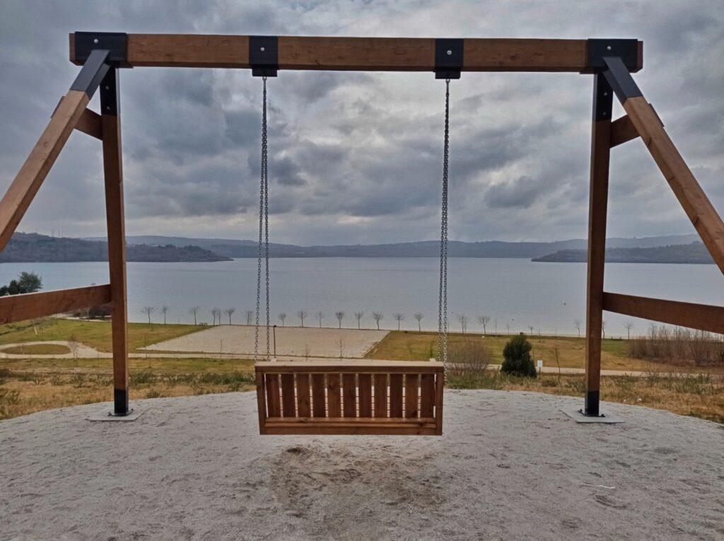 moody day, large wooden double swing in front of lake