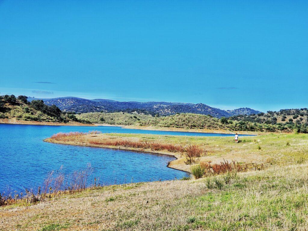 la ronquillo, gentle slope down to blue water, blue sky and hills in background