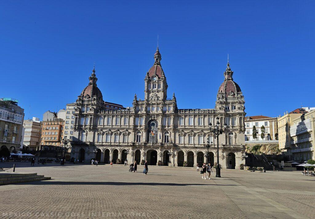 imposing building with three turrets on a mostly empty plaza