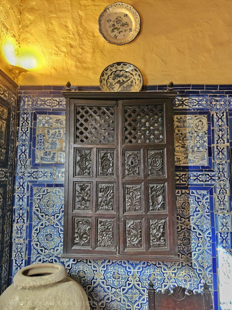 blue tiled walls, wooden cabinet, yellow wall above