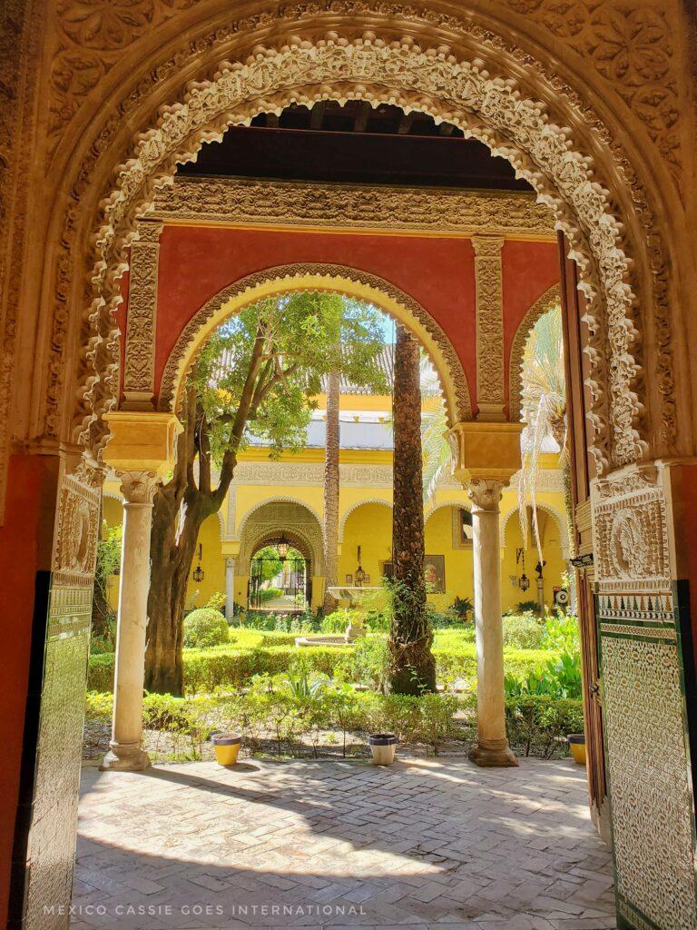 gorgeous ornate archways through to next room/ courtyard with green plants