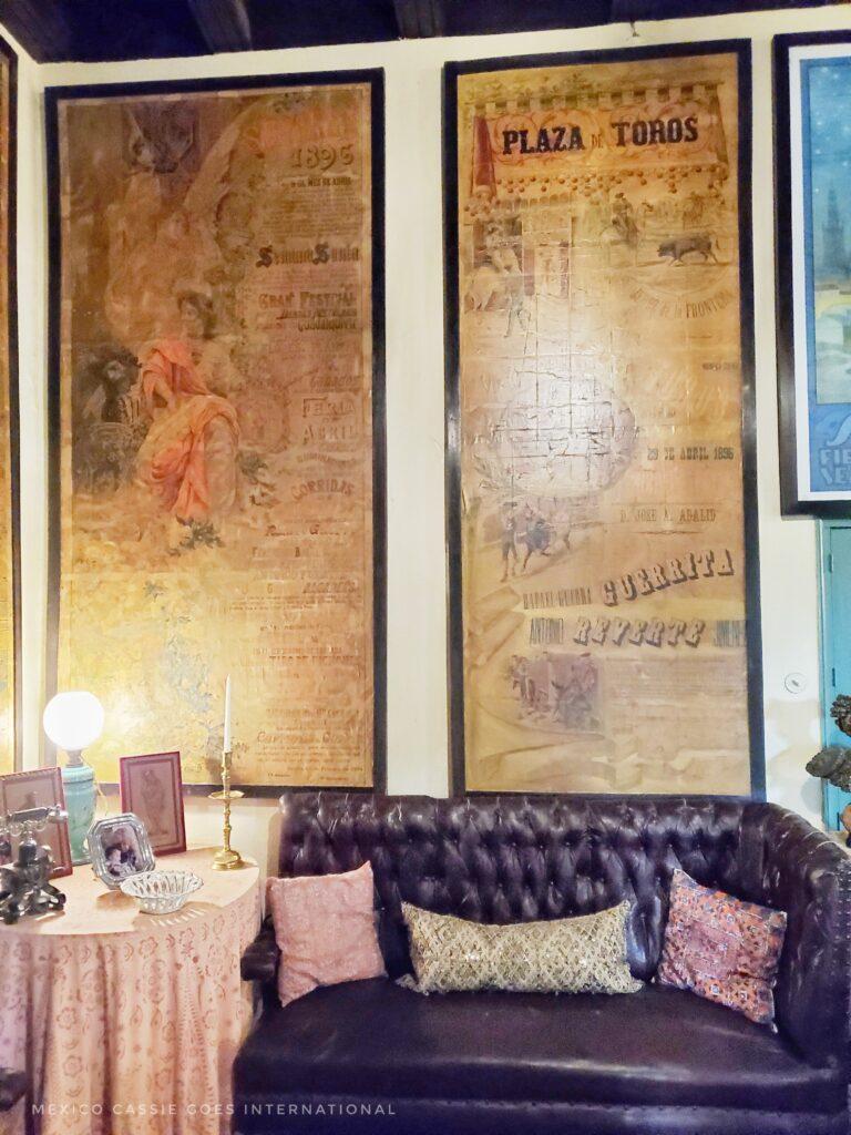 leather sofa, with 3 cusions, side table, two large posters on wall behind