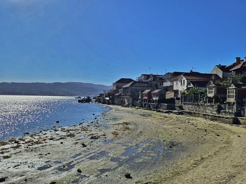 small urban beach with tide out. coast stretches out with houses on edge