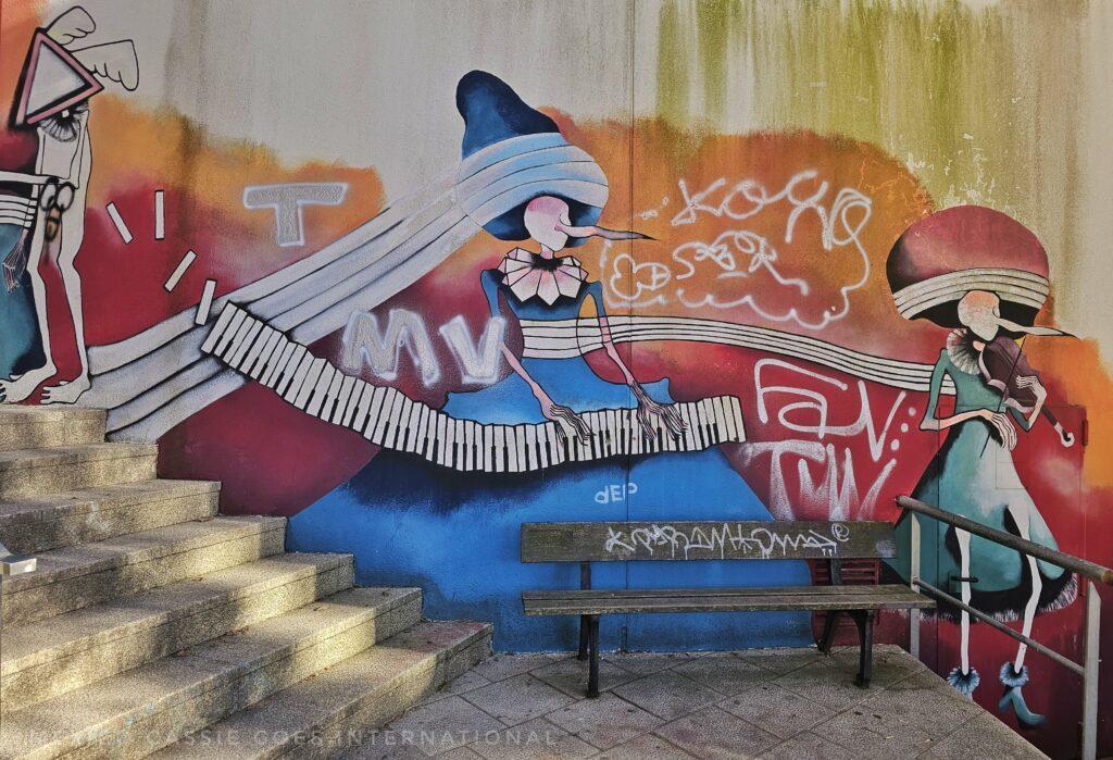 woman playing a keyboard, bright colours on wall behind